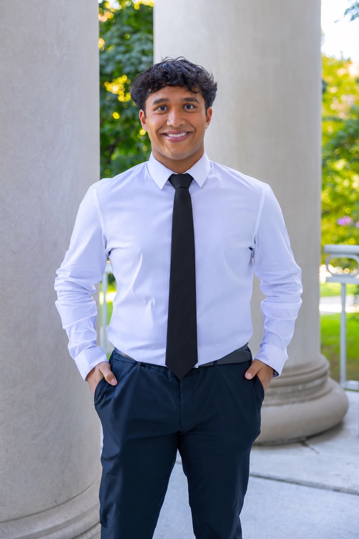 Ethan Skariah standing outdoors among columns